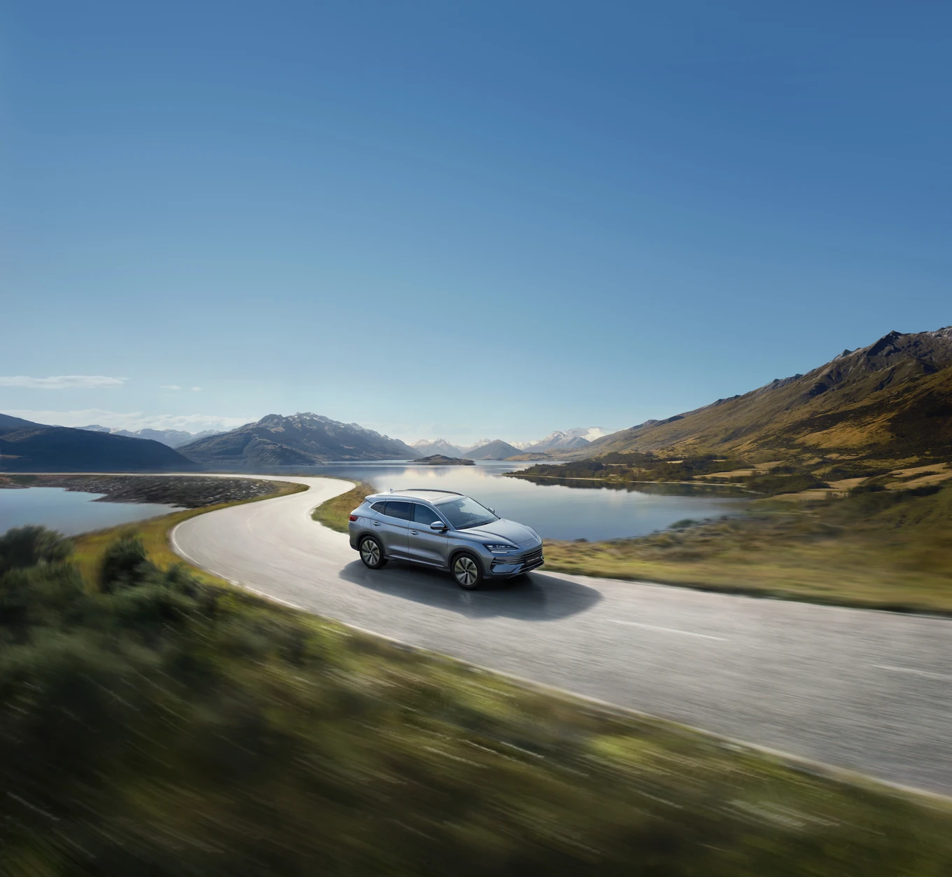 BYD SEAL U DM-i auf einer kurvigen Straße an einem Bergsee