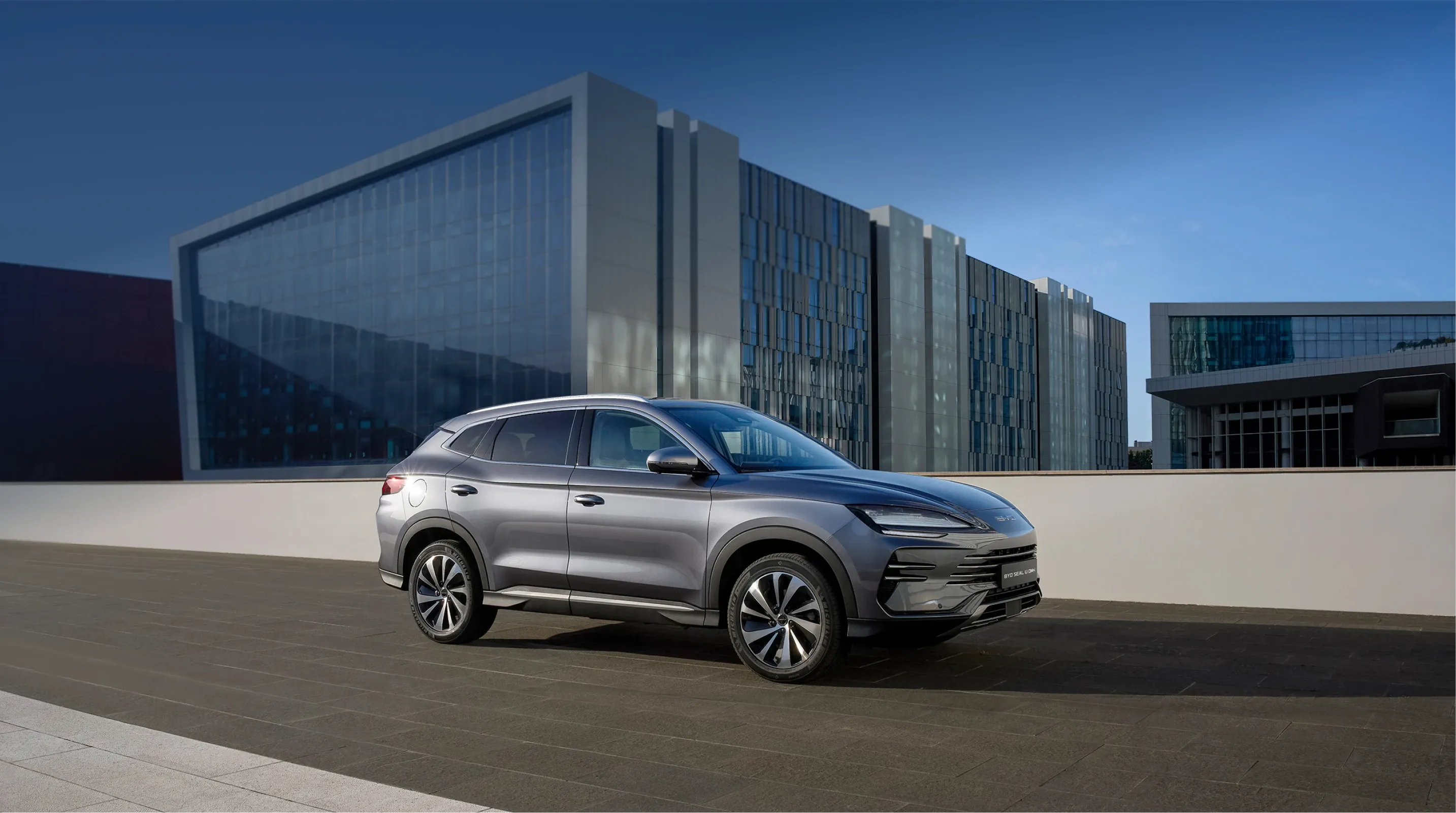 Grauer BYD SEAL U DM-i vor einem modernen Gebäude